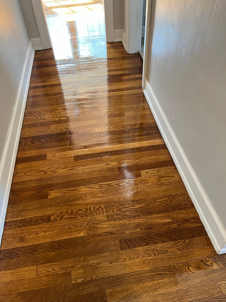 Warm wood floor leading through a narrow hallway