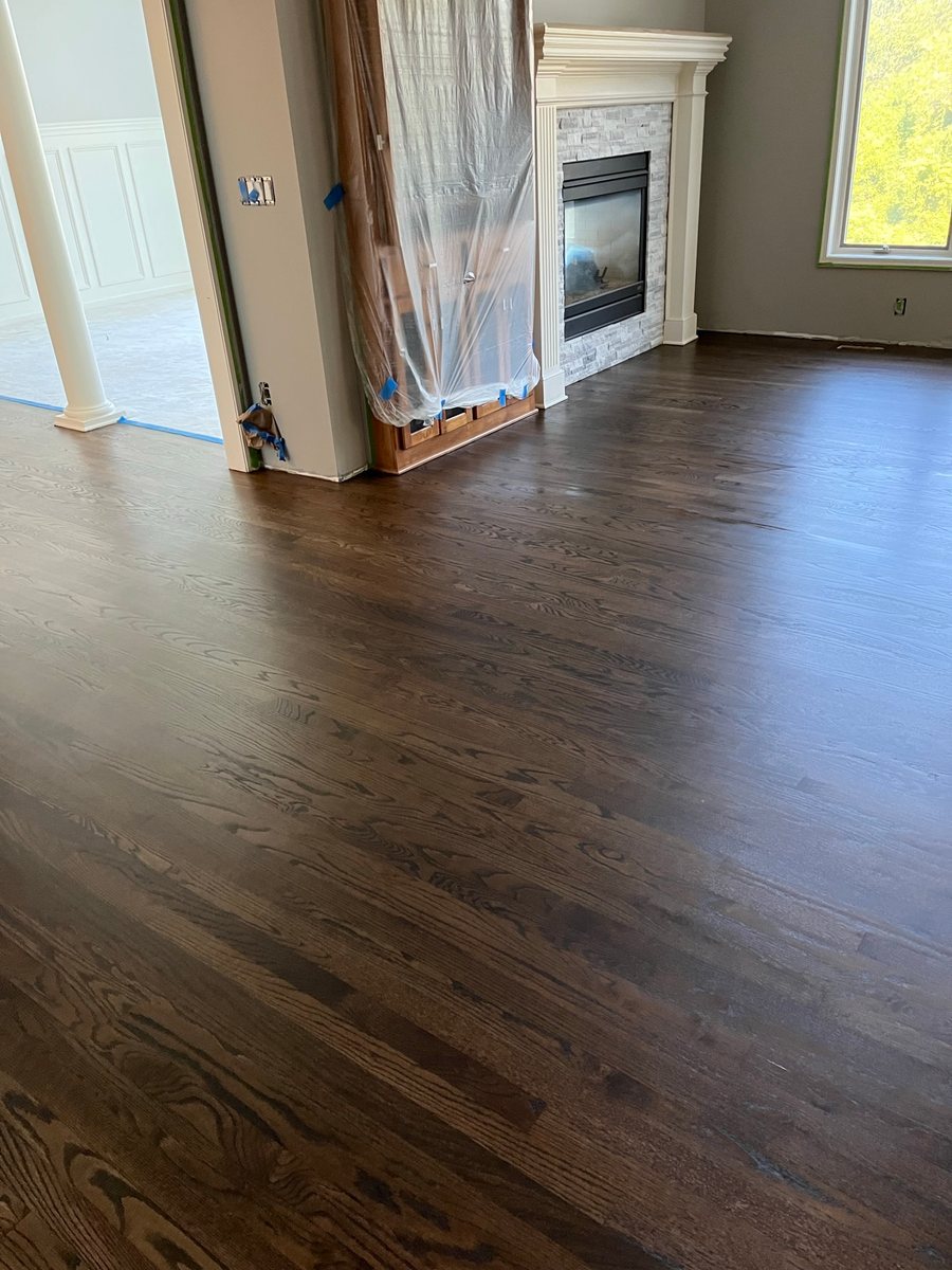 Dark wood floor in an open room with a fireplace
